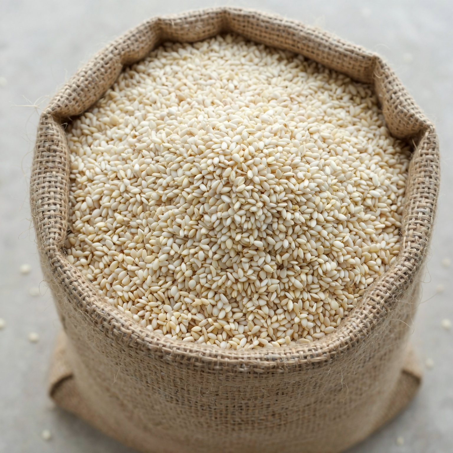 Daniel_Dangu_Design_a_big_bag_filled_with_sesame_seeds_with_the_top_open_,_mak_34a0315a-a9f9-4fff-87e7-eb08713a91be Model Version: lite | Model Category: Realism | Prompt: Photorealistic close-up of an open burlap sack overflowing with sesame seeds, visible texture of the burlap and individual seeds, natural studio lighting with subtle shadows, shallow depth of field focusing on the seeds, professional product photography, 4K quality. | Enhanced Prompt: A photorealistic close-up of an open burlap sack, its coarse, visible texture sharply defined, overflowing abundantly with hundreds of small, pale sesame seeds. The scene is controlled under natural studio lighting, which casts subtle, defined shadows that accentuate the granular texture of the seeds and the weave of the fabric. The composition is extremely tight, utilizing a very shallow depth of field that keeps the nearest cluster of seeds in crisp focus while the rest of the sack recedes into a soft bokeh. This is captured with a long-focus lens, emphasizing detail and texture, presented with the clarity of professional product photography in stunning 4K quality. Photorealistic close-up of an open burlap sack overflowing with sesame seeds, visible texture of the burlap and individual seeds, natural studio lighting with subtle shadows, shallow depth of field focusing on the seeds, professional product photography, 4K quality.
